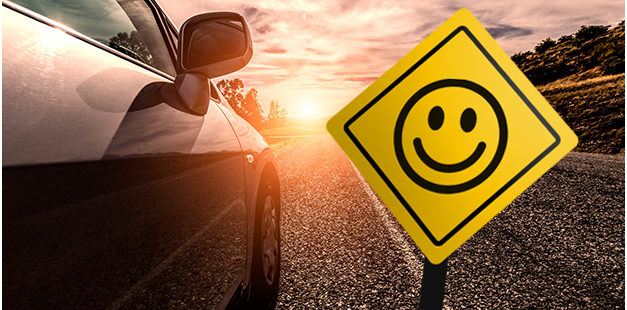 Carro passando e placa de sinalização sorrindo